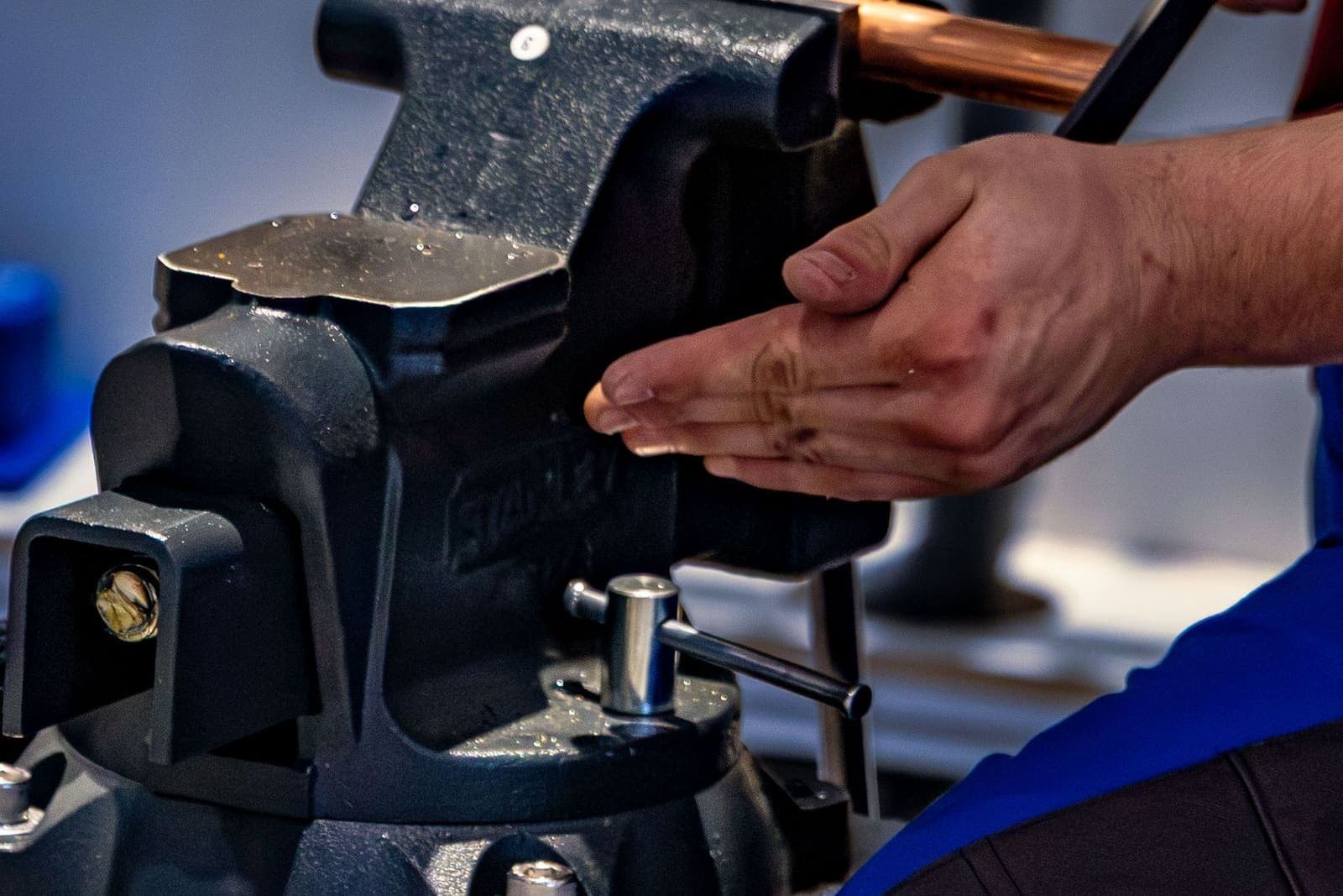 Plumber working on a copper pipe held in a vise